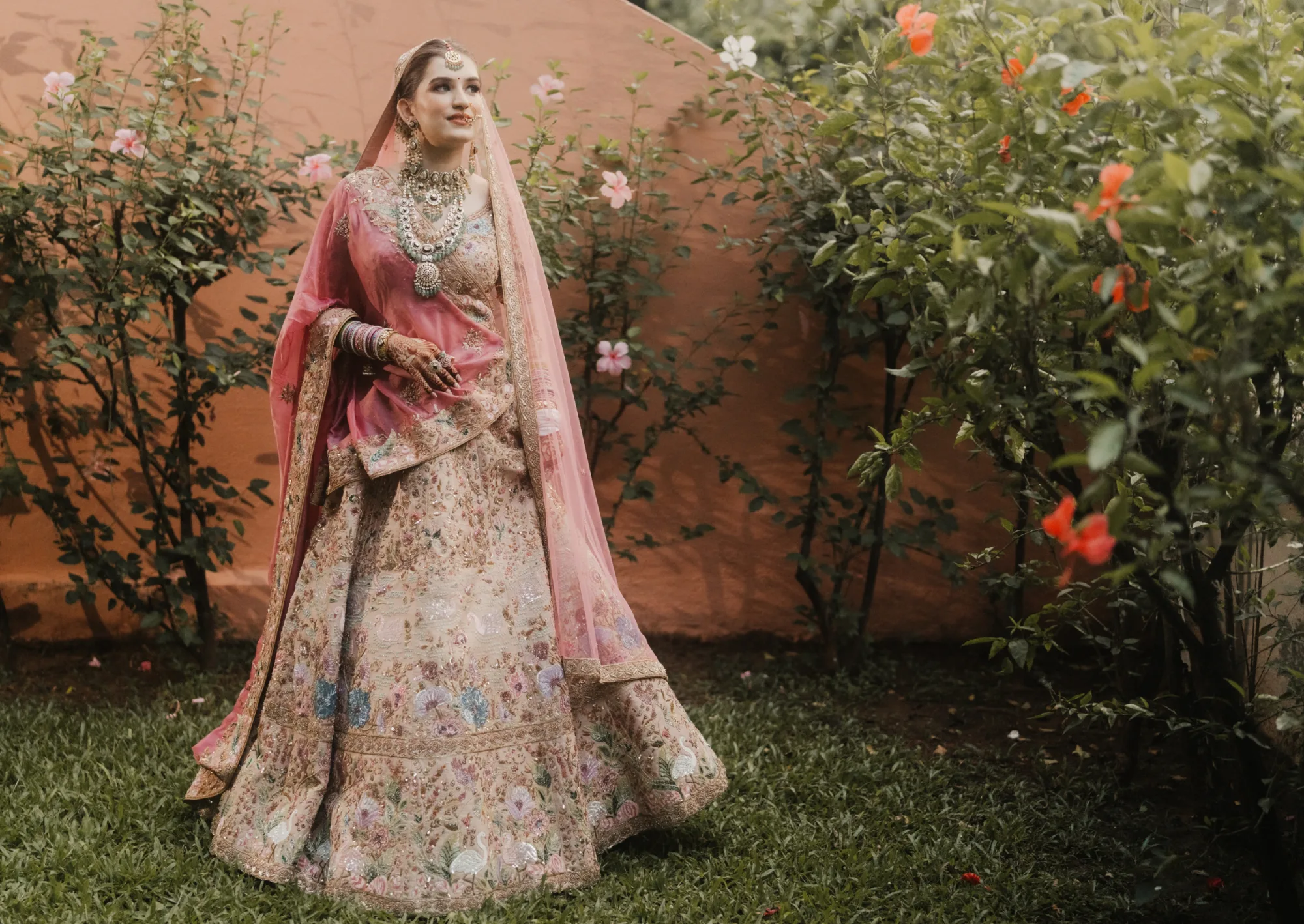 Coral lehenga bride in warm light — warm bridal colour palette